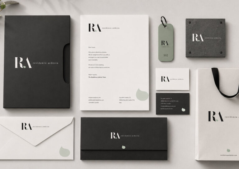 Brand identity immobiliare Residenza Ardesia con monogramma RA, palette ardesia e materiali coordinati