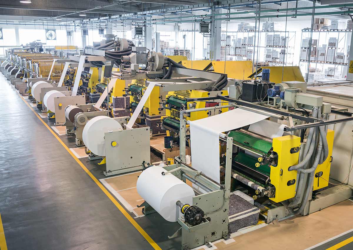 Reparto produttivo Adercarta con macchinari e operatori durante il servizio fotografico industriale